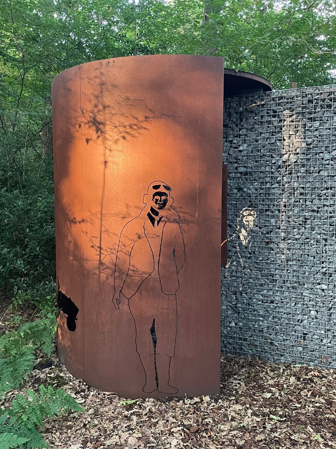 Het silhouet van Samuel J. Melancon op de cortenstalen cilinder