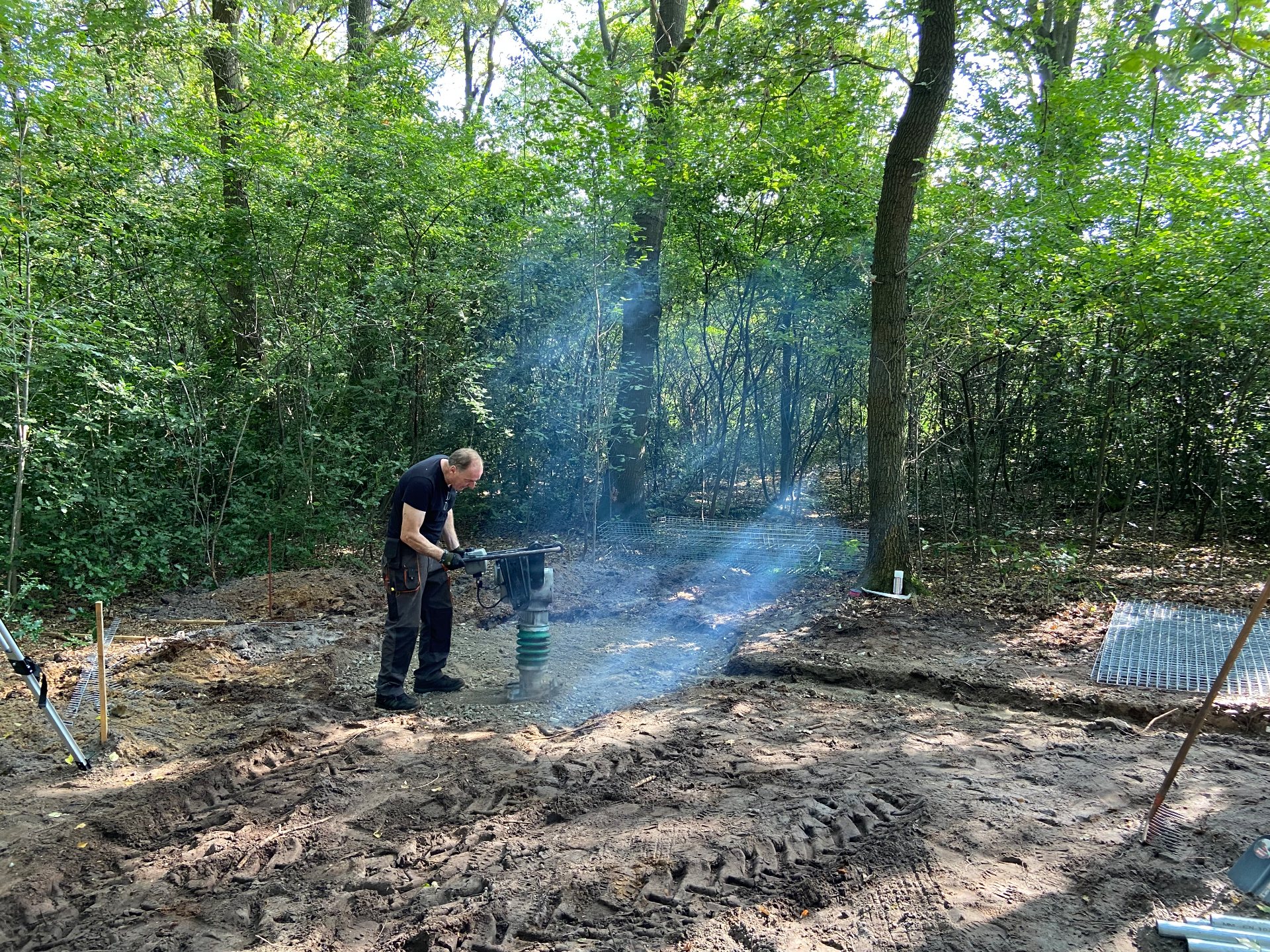 Een vakman verdicht de ondergrond voor het memorial